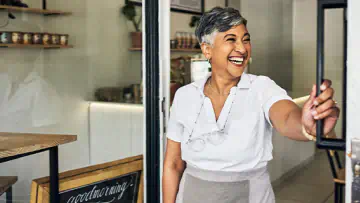 Business owner opens the door to her store